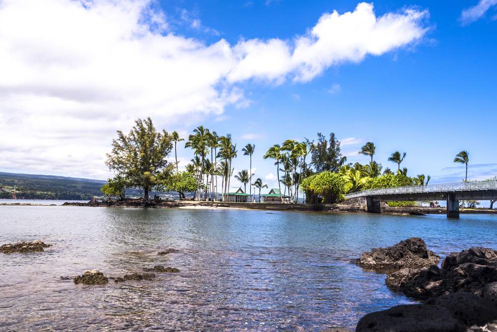 Coconut Island Hawaii depicts a calm day with gentle waves washing ashore highlighting the tropical climate and look of paradise.