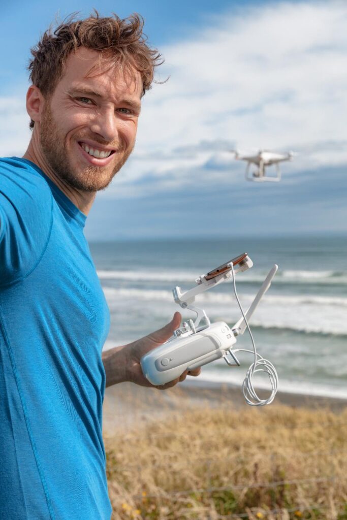 Image of a man flying a drone at a beach in Hawaii