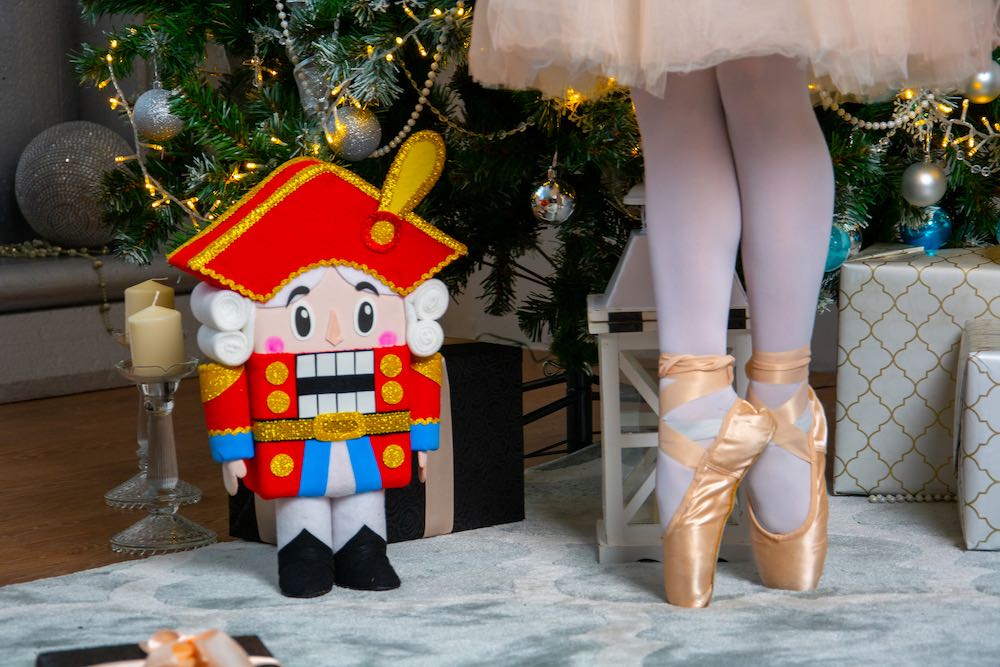 Feet of a ballerina on the background of a Christmas tree and a Nutcracker