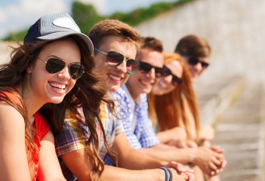 Check out these travel gifts for teens going to Hawaii recommended by top Hawaii blog Hawaii Travel with Kids! Image of a group of teens wearing sunglasses