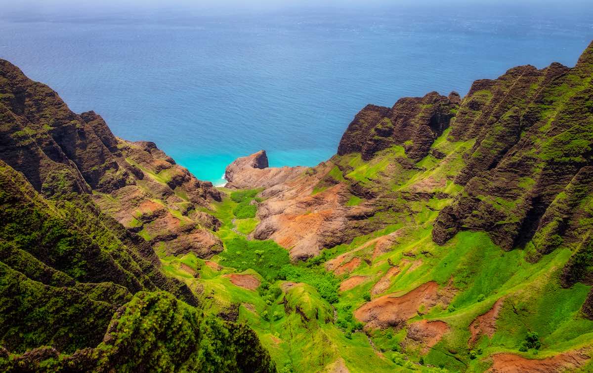 Find out the best things to do on Kauai in July by top Hawaii blog Hawaii Travel with Kids! Image of Aerial landscape view of Na Pali coastline, Kauai, Hawaii, USA
