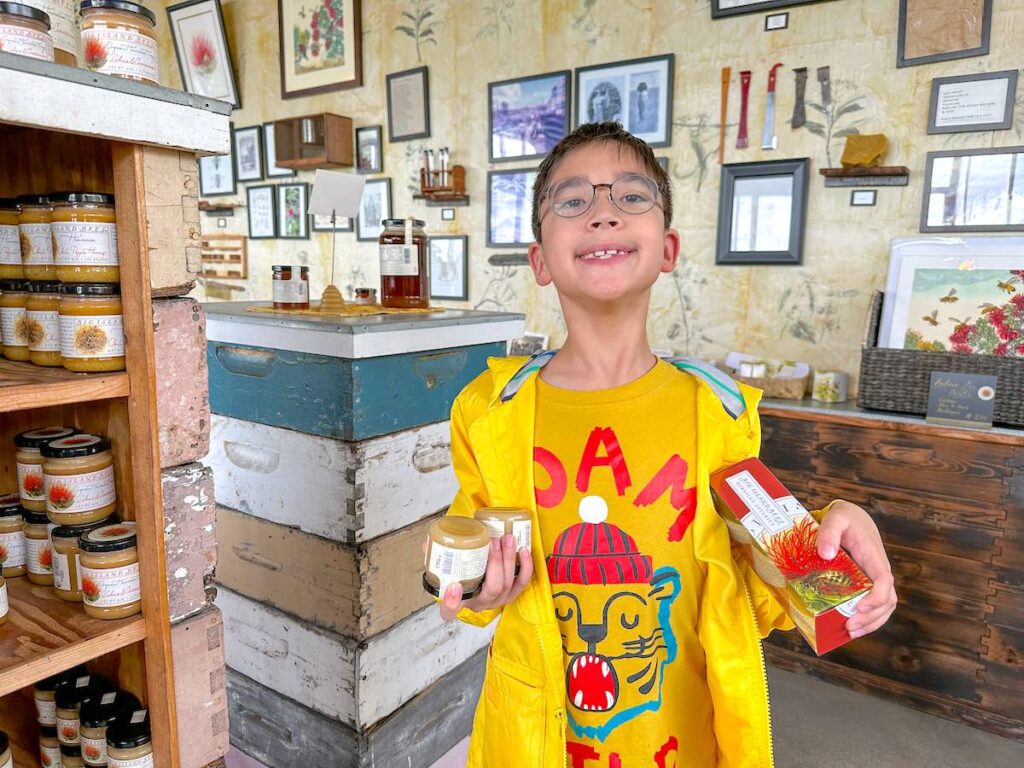 Image of a boy holding up jars of Big Island honey