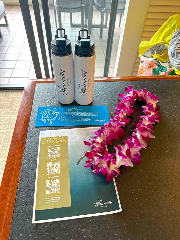 Image of reusable water bottles and an orchid lei.
