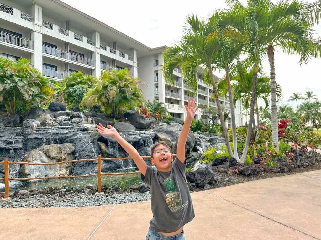 Image of a boy with his arms up in joy at the Fairmont Orchid in Kona