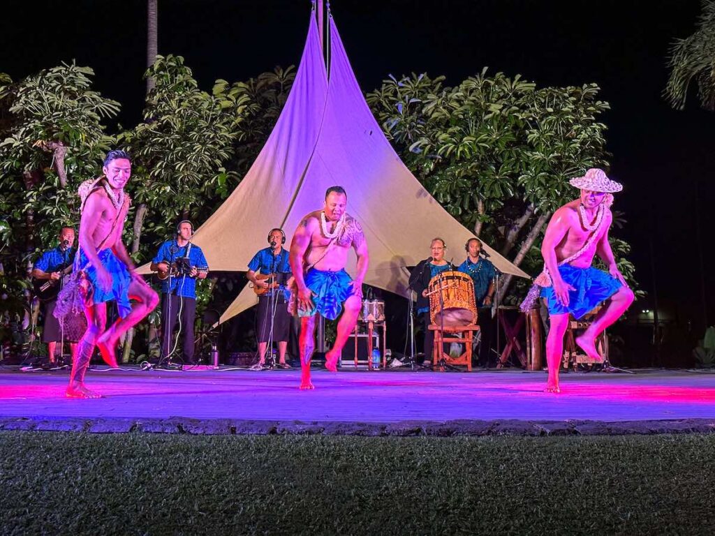 Image of men dancing hula wearing hats