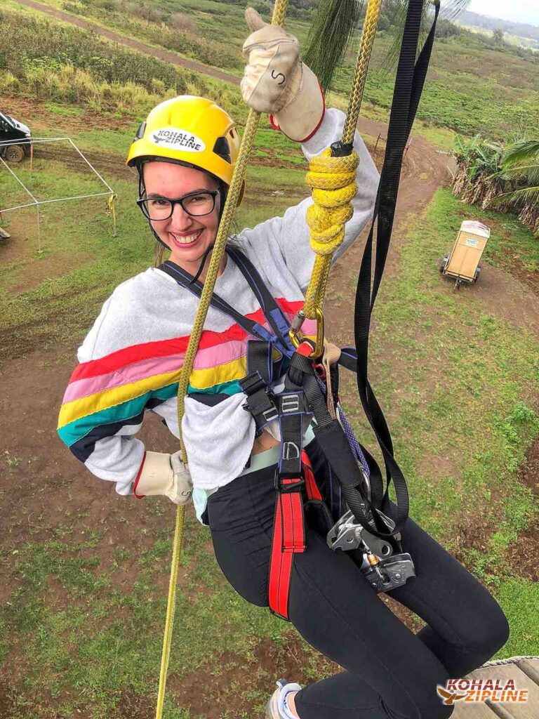 Image of a woman rappelling down from a ziplining platform