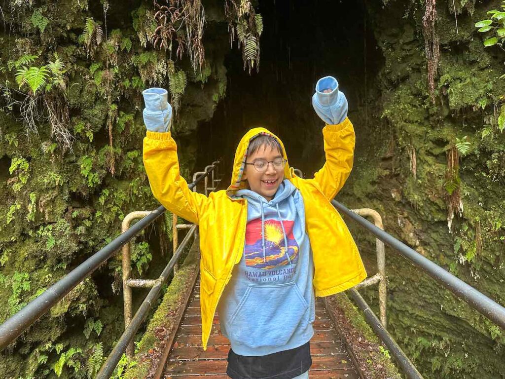 Image of a boy wearing a yellow rain jacket at the Kahuku Lava Tube