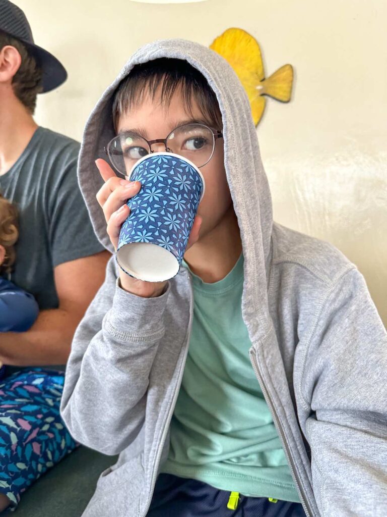 Image of a boy drinking ginger ale on the Kona Glassbottom Boat tour.