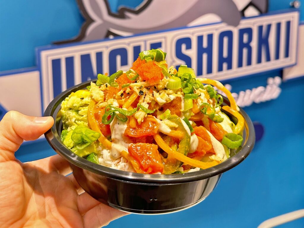 Image of a poke bowl in front of the Uncle Sharkii sign