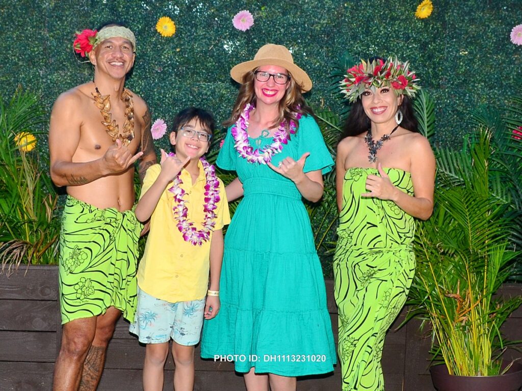 Image of Marcie Cheung of Hawaii Travel with Kids and her son with performers at the Diamond Head Luau in Waikiki