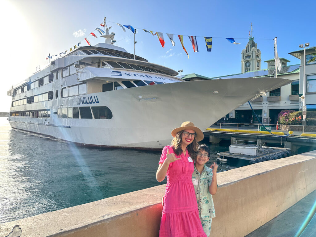 Check out this honest Star of Honolulu cruise review by top Hawaii blog Hawaii Travel with Kids. Image of Marcie Cheung and her son in front of the Star of Honolulu dinner cruise on Oahu.