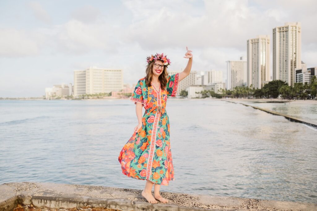 Image of Marcie Cheung of Hawaii Travel with Kids wearing a floral maxi dress at Waikiki Beach