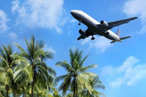 Find out the biggest Hawaii island hopping mistakes families make. Photo of an airplane over palm trees