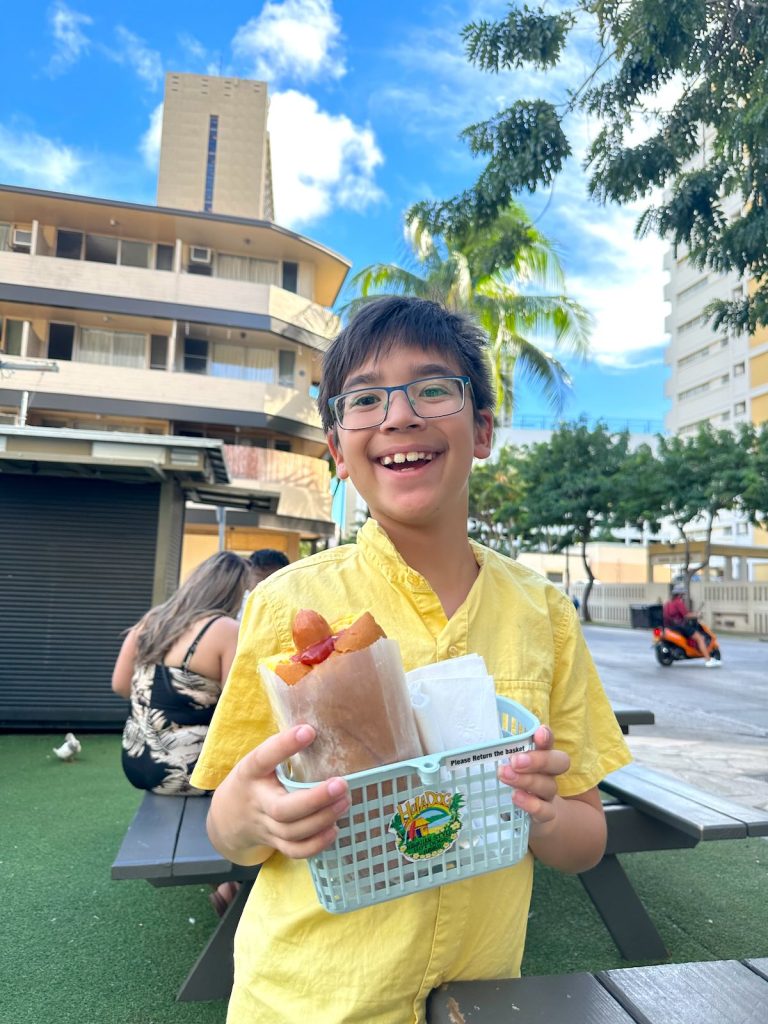 Image of a boy with a hot dog in Waikiki