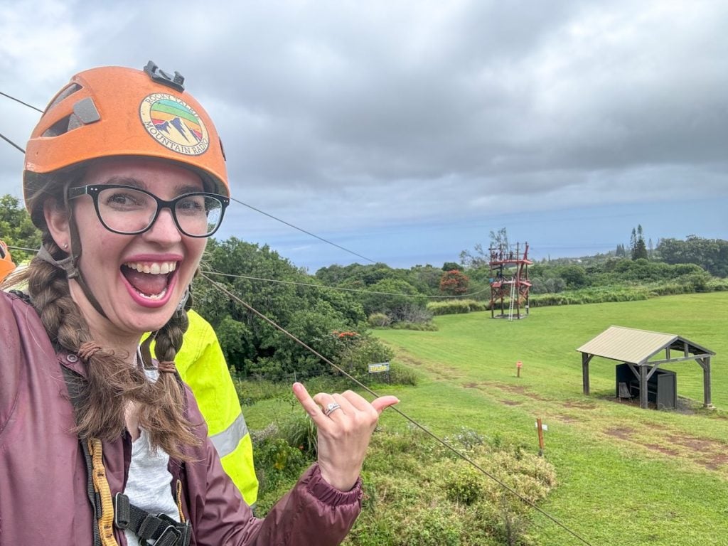 Check out this NorthShore Zipline review by top Hawaii blog Hawaii Travel with Kids. Image of Marcie Cheung at a zipline on Maui