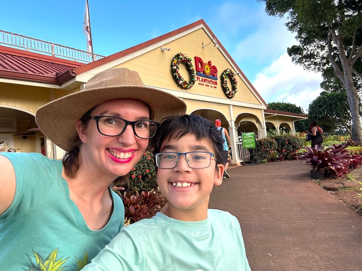 Image of Marcie Cheung of Hawaii Travel with kids with her son in front of Dole Plantation.