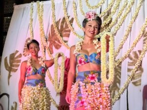 See this honest Na Lei Aloha Waikiki luau review by top Hawaii travel expert Marcie Cheung. Image of 2 hula dancers with leis.